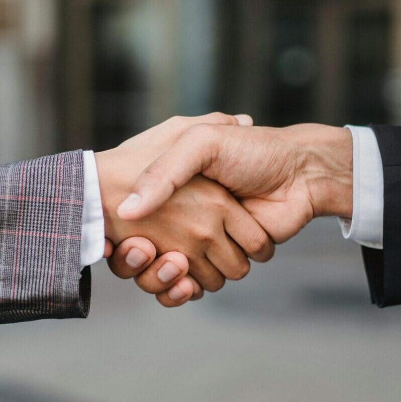 A close-up of two businesspeople shaking hands, symbolizing cooperation and partnership.