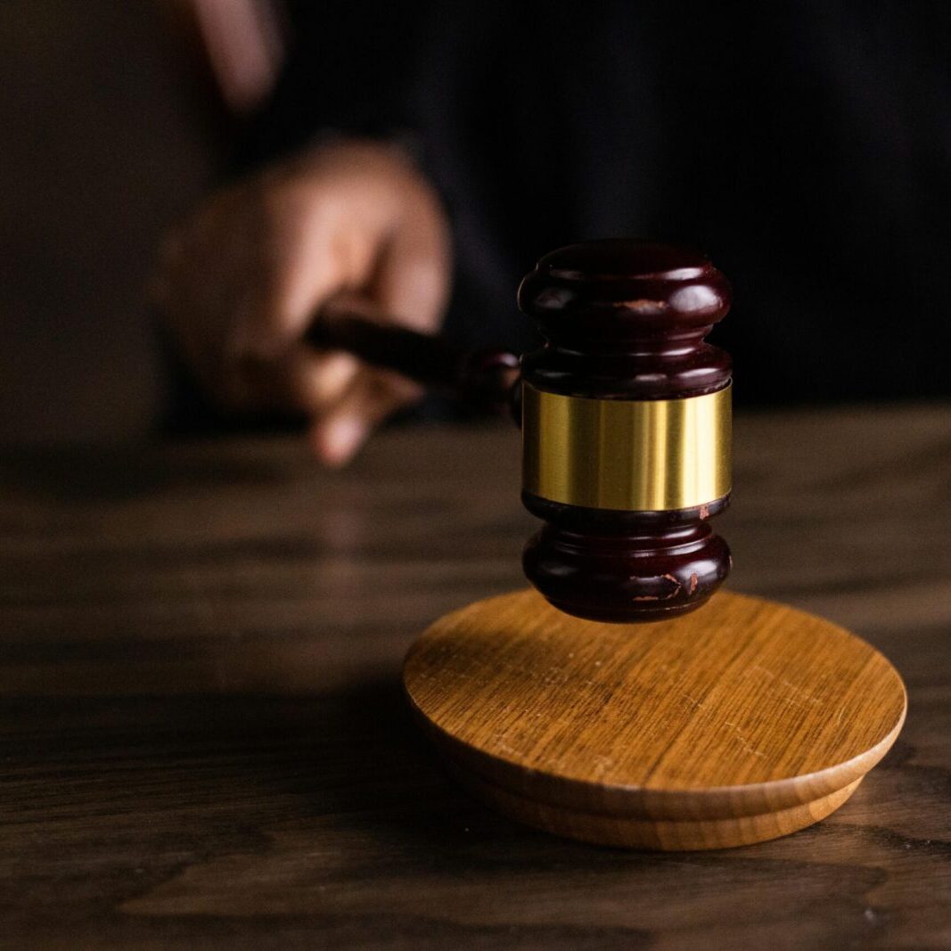 A gavel striking a sound block, symbolizing justice and legal authority in a courtroom setting.
