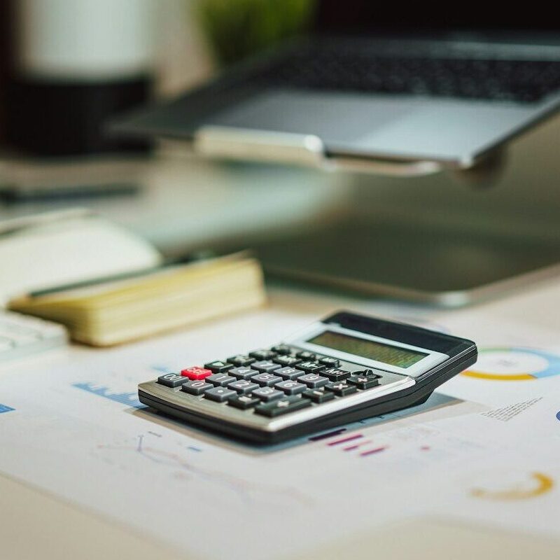 a calculator sitting on top of a table next to a laptop